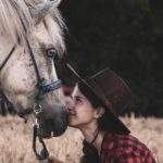 ragazza e cavallo muso contro muso che si guardano.