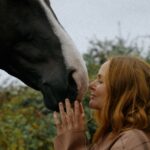 Stella McCartney accarezza un cavallo